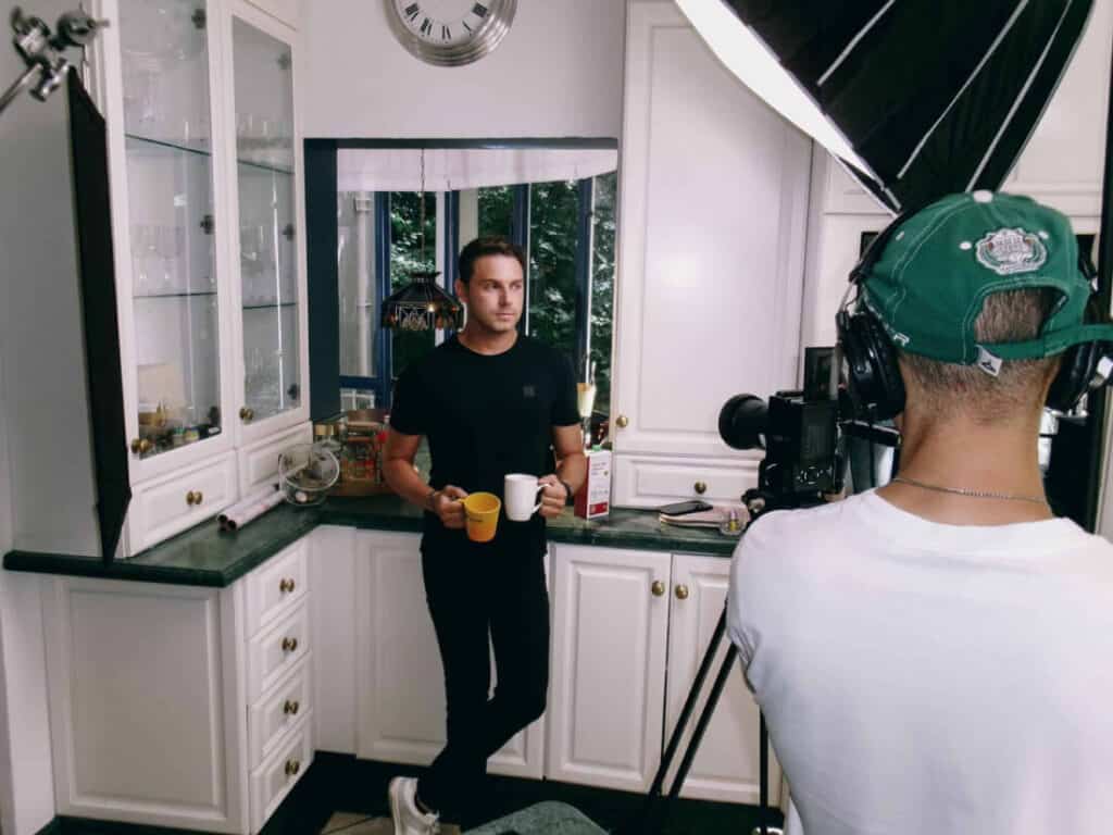 man holding 2 cups behinds the scene shoot
