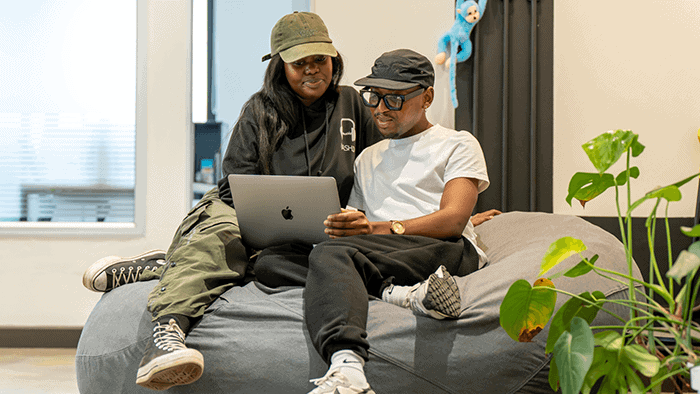 Katlego and Xolani sitting on beanbag looking at a laptop